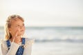 One adorable little girl thinking of ideas while standing on a beach outdoors. A cute young kid looking thoughtful while Royalty Free Stock Photo