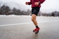 One adult caucasian man running in winter day male athlete runner training on the open road in nature with snow health and fitness