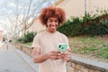 One african american teenager using a cellphone to send funny messages. Isolated happy young man smiling and having fun Royalty Free Stock Photo