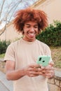 One african american teenager using a cellphone to send funny messages. Isolated happy young man smiling and having fun Royalty Free Stock Photo