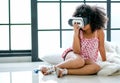 One African mixed race girl enjoy with VR glasses and sit on floor in the room with day light