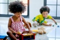 One African mixed race girl is playing with toys in front of the other boy and look enjoy and happy with this activity Royalty Free Stock Photo