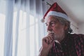 One alone and sad senior mature man sitting on the sofa at home celebrating christmas day alone with anyone people - upset adult Royalty Free Stock Photo