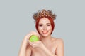 One apple a day keeps doctor away. Beauty queen smiling holding green apple toothy smile pretty woman with crystal crown on head