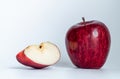 One apple and a half cut apple near each other, placed on a white table., Isolated apples. Whole red apple fruit with slice cut Royalty Free Stock Photo