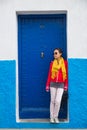 One asian woman stands in front of navy metal door Royalty Free Stock Photo