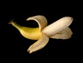 One Banana, half peeled, on a black background isolated Royalty Free Stock Photo