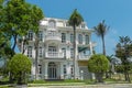 One beautiful four-story house with palm trees, trees, and landscape design in the summer