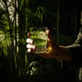 one beautiful cocktail glass being held by a man\'s 2