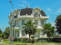 One beautiful three-story house with palm trees, trees, and landscape design in the summer.