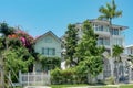 One beautiful three-story house with palm trees, trees, and landscape design in the summer.