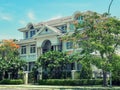 One beautiful three-story house with trees, and landscape design in the summer.