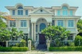 One beautiful three-story house with trees, and landscape design in the summer.