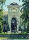 One beautiful two-story house with palm trees, trees, and landscape design in the summer.