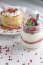 Berry breakfast yogurt pot with a stack of hotcakes