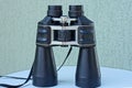 One big black binoculars stands on a white table Royalty Free Stock Photo