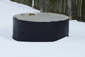 One big black concrete ring in a snowdrift of white snow