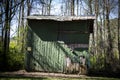 One big green storage shed surrounded by tall green trees