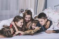 One big happy family. Mom reads a book to their children in bed. Royalty Free Stock Photo