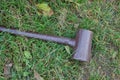 One big iron brown hammer lies on the ground