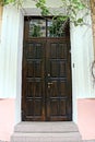 One big old brown door made of wood and glass on a concrete wall Royalty Free Stock Photo