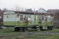 one big old green metal trailer in brown rust on wheels with windows