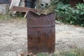 One big old rusty brown barrel with garbage