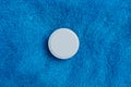 One round white tablet on blue wool background Royalty Free Stock Photo