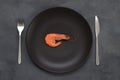 One 1 big shrimp on black plate on gray. Healthy sea food. Minimalism, keto weight loss diet concept. Top view. Man Royalty Free Stock Photo