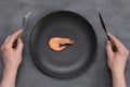 One 1 big shrimp on black plate on gray. Healthy sea food. Minimalism, keto weight loss diet concept. Top view. Man Royalty Free Stock Photo