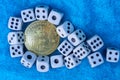 Bitcoin yellow coin and white game dice on blue wool