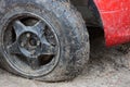 Black flat tire of a red car on a dirt road Royalty Free Stock Photo