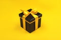 One black gift box on yellow background.