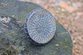 one black old plastic round watering can piece lies on a gray stump Royalty Free Stock Photo