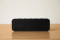One black portable bluetooth speaker on wooden table. Audio equipment Royalty Free Stock Photo