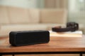 One black portable bluetooth speaker on wooden table indoors, space for text. Audio equipment Royalty Free Stock Photo
