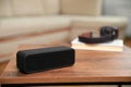 One black portable bluetooth speaker on wooden table indoors, space for text. Audio equipment Royalty Free Stock Photo