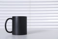 One blank black ceramic mug on white table. Mockup for design Royalty Free Stock Photo