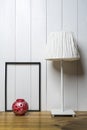 One blank black frame, a red candle holder and a lamp Royalty Free Stock Photo