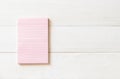 One blank pastel sweet pink color reminder paper pad with horizontal line stripes on white pine wood