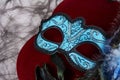 One blue carnival mask with feathers on the red Royalty Free Stock Photo