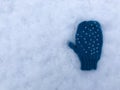 One blue knitted heart pattern baby child glove on snow background isolated Royalty Free Stock Photo