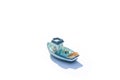 One blue miniature ship with shadow isolated on white background. blue ceramic boat
