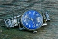 blue old shabby watch with a metal strap on a gray table Royalty Free Stock Photo