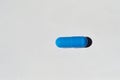 one blue pill lying on a white background Royalty Free Stock Photo