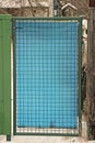 One blue plastic closed door with a green iron grate Royalty Free Stock Photo