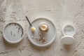 One boiled egg in stoneware egg cup with egg shell broken pieces in concrete tray, salt flakes and pepper Royalty Free Stock Photo