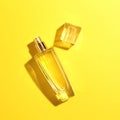 one bottle flacon of women's perfume with shadow on a yellow background.