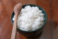 One bowl of white rice and wooden spoon on brown wooden table Royalty Free Stock Photo