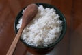 One bowl of white rice and wooden spoon on brown wooden table Royalty Free Stock Photo